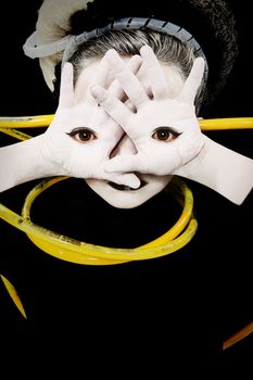 Alien girl child portrait with eyes on palms of hands and yellow tubes attached.