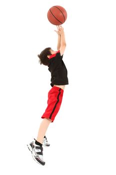 Energetic 8 year old boy child in basketball uniform jumping for shot.