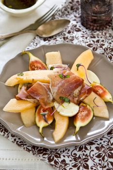 Fig,Cantaloupe with Prosciutto and Mozzarella salad [ Antipasti ] with purple sprout on top by Balsamic dressing