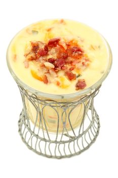Decorative bowl of Irish Potato Soup with bacon and cheddar. Over white background.