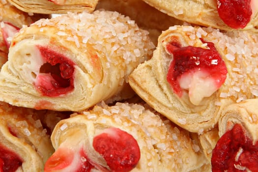 Raspberry filled pastries with sugar sprinkles up close.