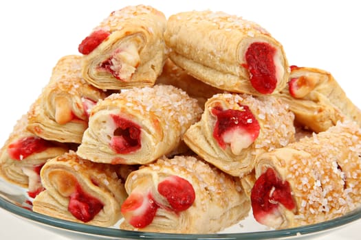 Plate of raspberry filled pastries over white background.