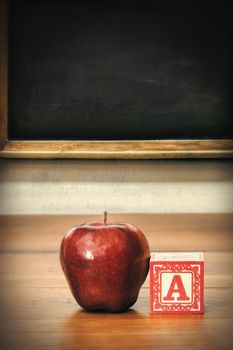 Delicious red apple on old school desk