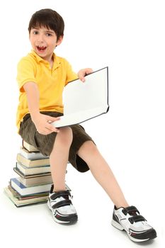 Adorable elementary age school boy child making faces on stack of books.