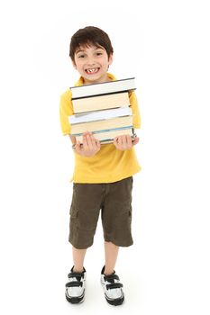 Adorable back to school boy child with stack of text books in arms walking over white background.