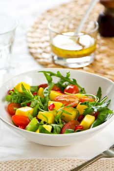 Mango,Pomegranate and cherry tomato with rocket salad in a bowl by vinaigrette