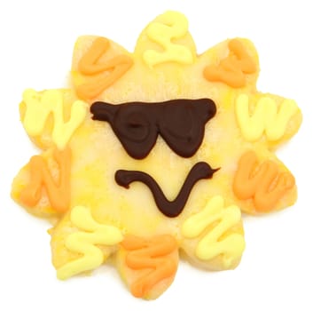 Large yellow sugar cookie shaped like a sunshine face with sunglasses over white background.