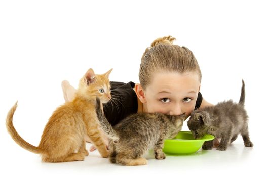 Adorable young girl child drinking out of kitten's milk bowl.  Over white background.