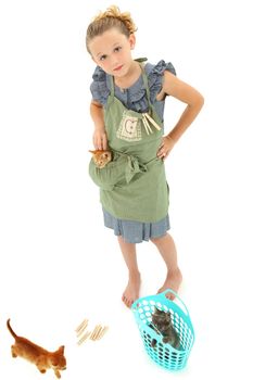 Adorable Girl Child in Apron playing house homemaker with kittens.  Retro dress and apron over white background.