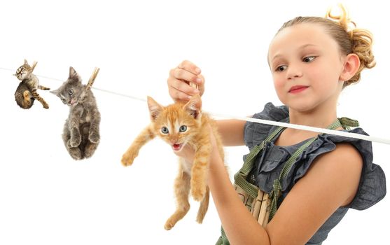 Image manipulation of girl child hanging kittens on a clothes line over white background.
