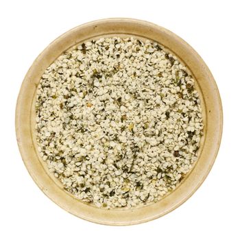 shelled hemp seeds in a round ceramic bowl isolated on white