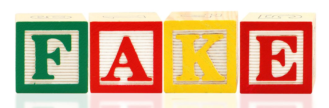 Colorful alphabet blocks spelling the word FAKE over white.