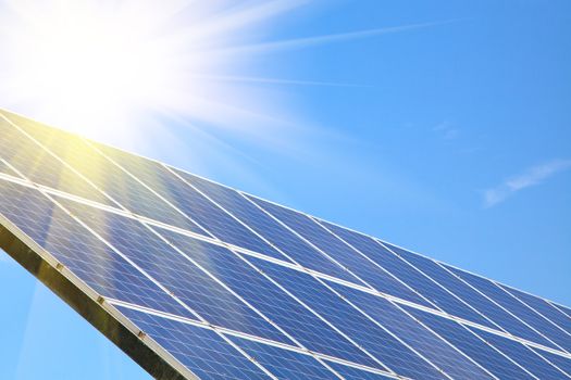 Solar panel against blue sky with sun