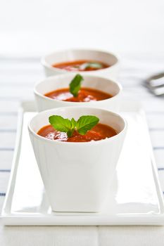 Tomato soup with basil in cups
