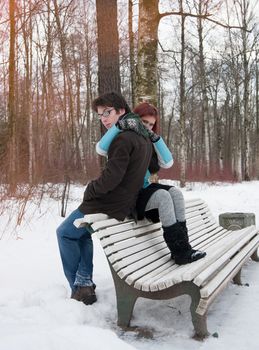 boy and girl sitting on a bench in winter