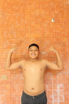 Portrait of Thai teen boy showing off his Muscles