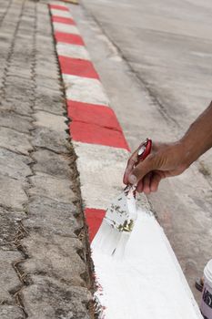 Painting white and red no standing and parking sign on footpath