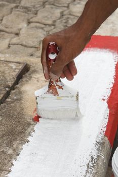 Painting white and red no standing and parking sign on footpath