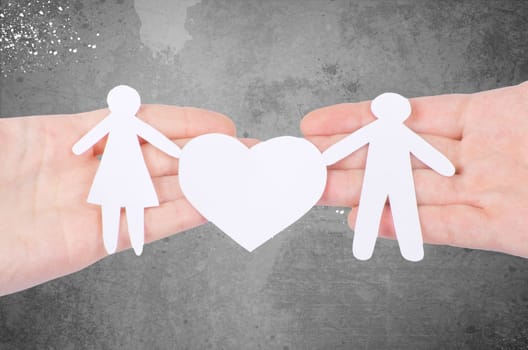 Paper family in hand with a big hearth isolated on white