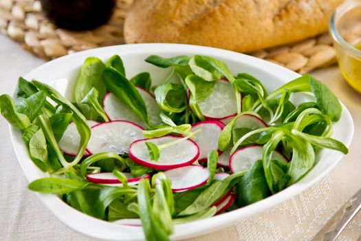 Radish,Corn salad salad with mustard dressing by a loft of bread