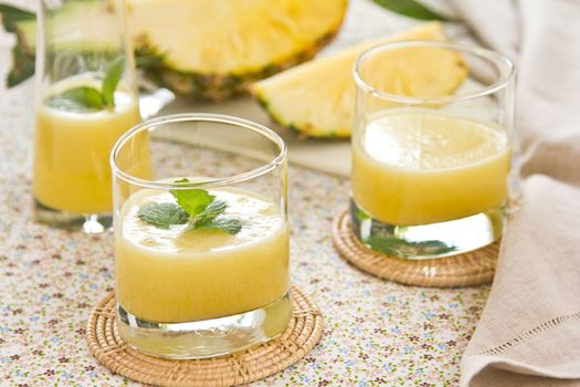 Pineapple juice [smoothie] with mint on top by fresh pineapple