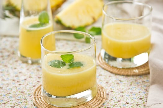 Pineapple juice [smoothie] with mint on top by fresh pineapple