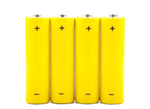 Four yellow batteries isolated over white background
