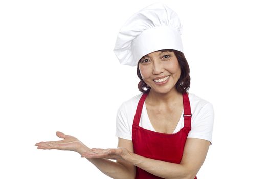 Smiling asian chef gesturing guests to take their seats. All on white background
