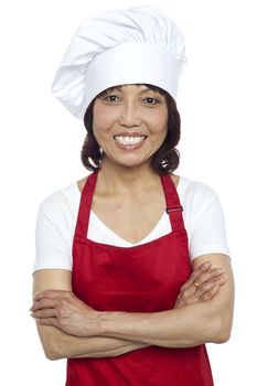 Confident smiling chef posing with her arms crossed isolated over white