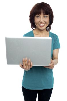 Casual asian girl holding laptop isolated against white background