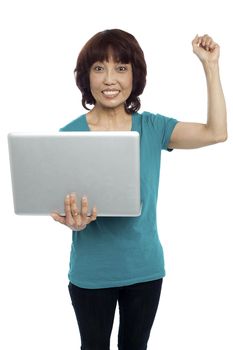 Casual asian girl holding the laptop in one arm with other one raised. All on white background