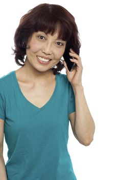 Pretty female communicating through cellphone, looking at you