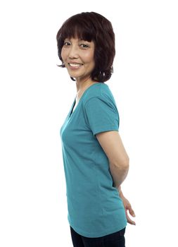 Asian model posing with her hands behind. Looking at you