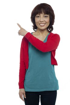 Asian model pointing at the copy space area. Half length portrait