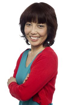 Side pose of smiling asian woman, arms crossed. Isolated on white