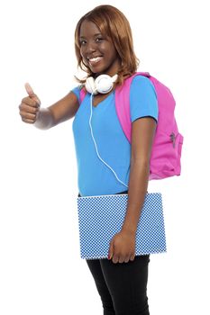 Stylish african college girl showing thumbs up to camera. All on white background