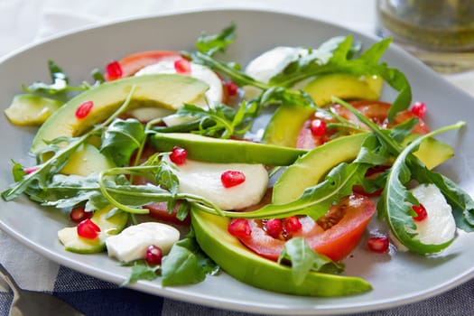 Avocado, mozzarella with pomegranate and rocket salad by pesto dressing