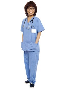 Asian surgeon posing with hands in her coat pocket isolated against white