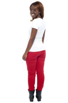 Smiling african lady in boots turning back, full length shot over white background