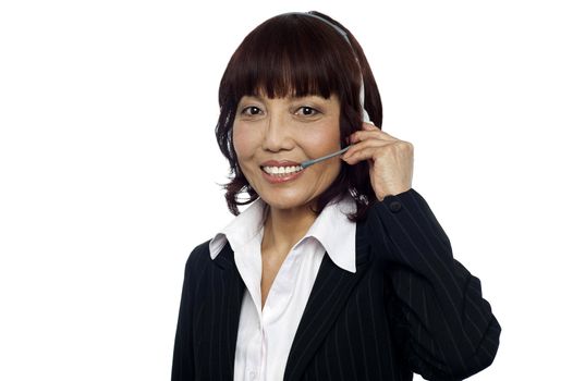 Cheerful asian customer support operator wearing headsets isolated over white background
