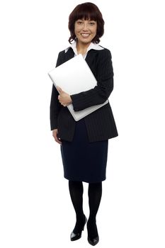 Female executive posing with laptop, full length shot isolated over white background