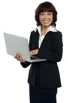 Portrait of a businesswoman working on laptop. Looking at camera and smiling