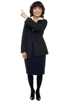 Female representative pointing at copy space area behind her. All on white background