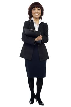 Female secretary holding clipboard, waiting for boss to arrive in the office