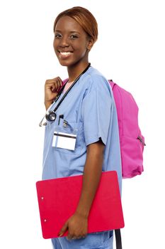 Female nurse under training holding her backpack and clipboard to write down notes
