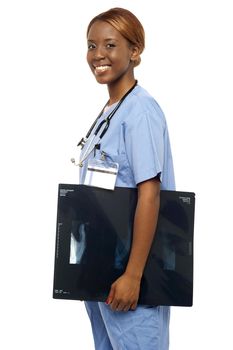 Nurse carrying x-ray reports to doctor. Looking at camera and smiling
