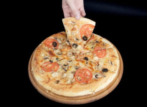 Pizza and slice of pizza in hand