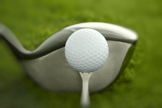Golf club and ball in grass