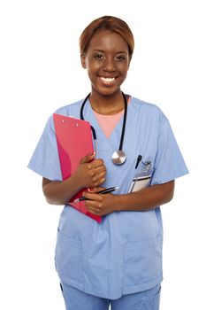 Female practitioner ready to assist senior doctor. Holding clipboard and smiling at camera