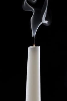 extinguished candle with smoke, isolated over black